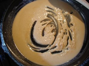 Browning flour in a skillet.