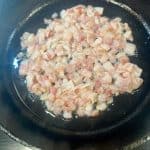 diced bacon cooking in a skillet