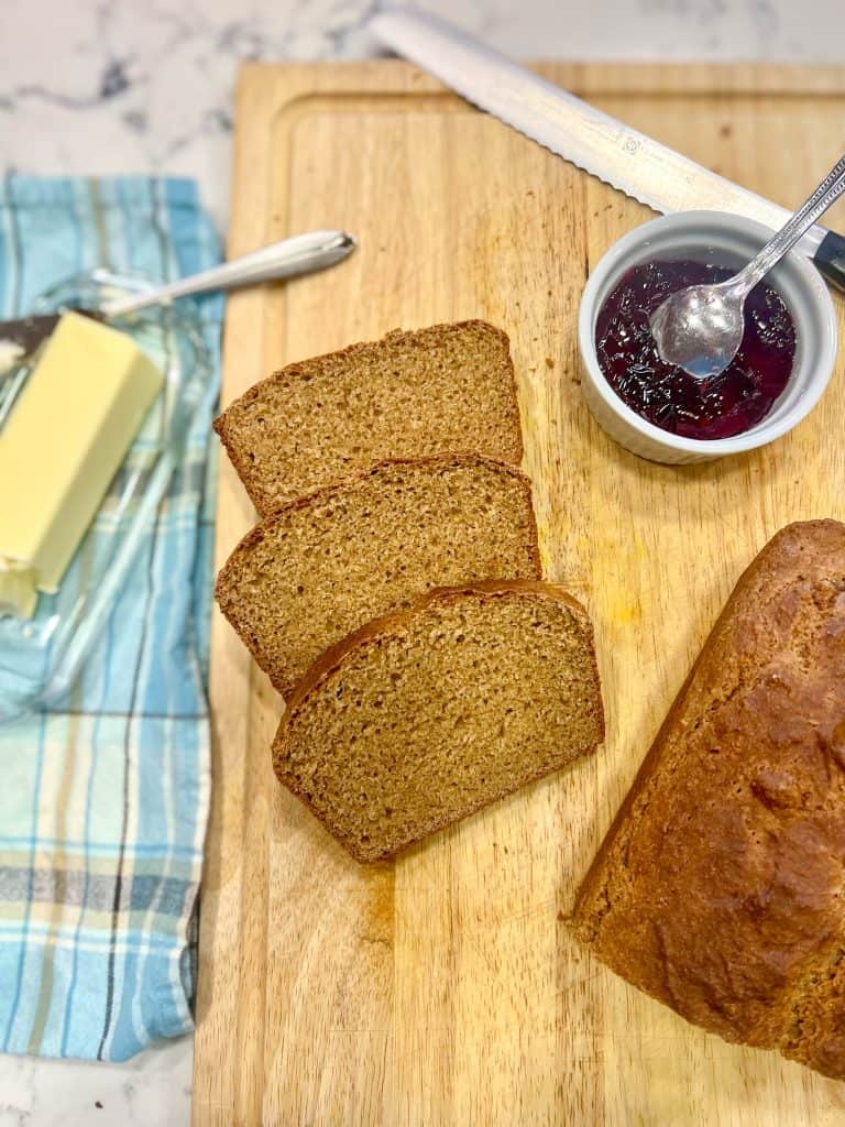 colonial brown bread on a board with butter and jam