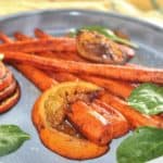 roasted carrots and oranges on a blue plate