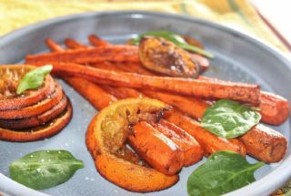 roasted carrots and oranges on a blue plate