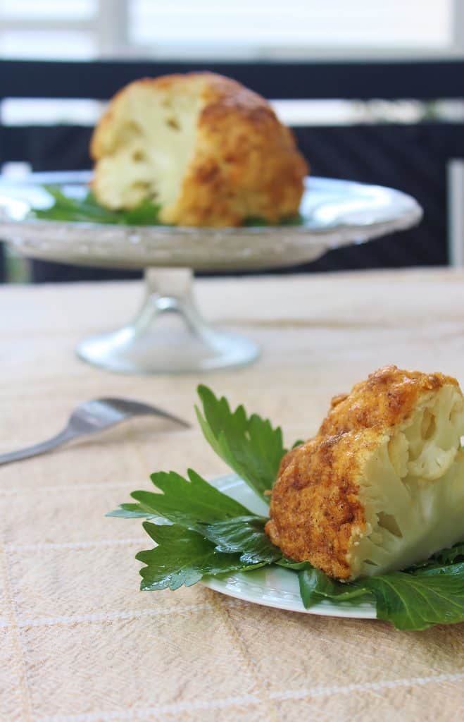 whole roasted cauliflower on a plate.