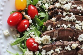 sirloin steak and arugula salad on a dinner plate