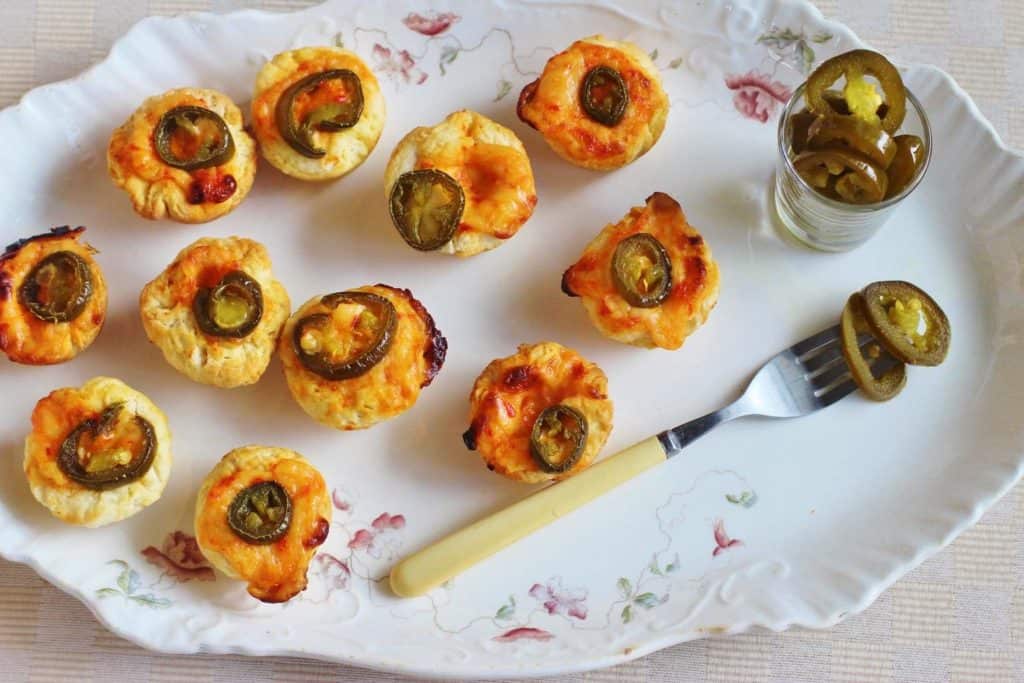 Spicy Pimento Cheese Biscuit Bites. Small biscuit cups filled with pimento cheese , topped with a pickled jalapeno slice and baked. 