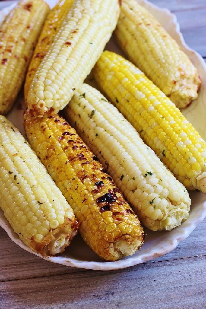 Herb and Parmesan Roasted Corn.. Fresh shucked corn is slathered with a compound butter containing fresh herbs, Parmesan cheese and a seasoning blend, wrapped in foil and grilled