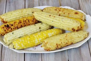 Herb and Parmesan Grilled Corn.. Fresh shucked corn is slathered with a compound butter containing fresh herbs, Parmesan cheese and a seasoning blend, wrapped in foil and grilled