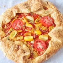 Rustic Tomato Pie. A free-formed butter crust with an herb goat cheese filling topped with fresh sliced tomatoes.
