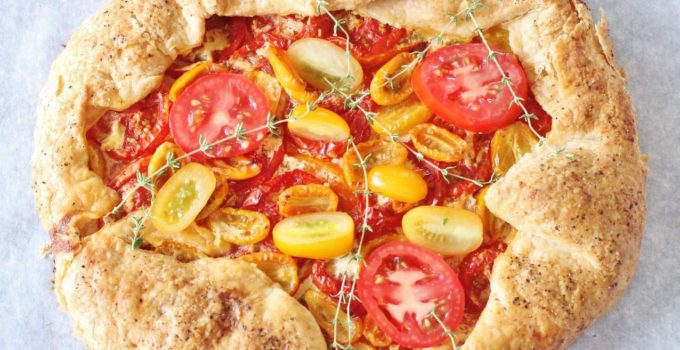 Rustic Tomato Pie. A free-formed butter crust with an herb goat cheese filling topped with fresh sliced tomatoes.