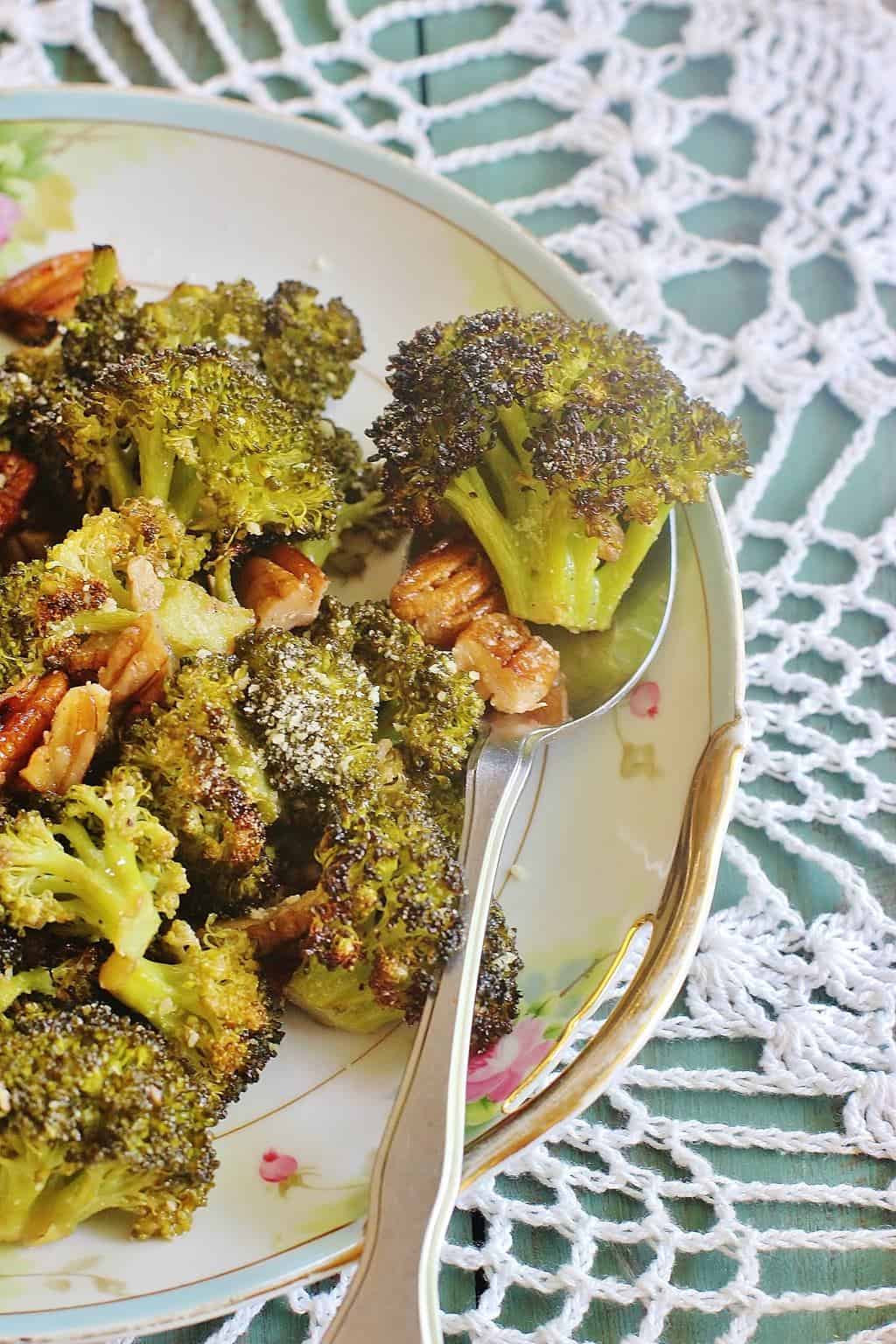 Roasted Broccoli and Pecans. Broccoli florets and pecans tossed in a lemon garlic vinaigrette and roasted till brown. Sprinkle with Parmesan cheese. #syrupandbiscuits #broccoli