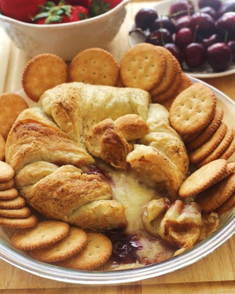 Brie topped with raspberry jam and baked in a puff pastry with crackers.