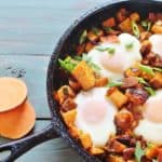 Sweet Potato Bacon Hash with Baked Eggs. A skillet meal of sweet potatoes, sweet onions, bacon and eggs. From the cookbook "Sweet Potato Love" by Jackie Garvin.