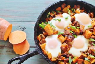 Sweet Potato Bacon Hash with Baked Eggs. A skillet meal of sweet potatoes, sweet onions, bacon and eggs. From the cookbook "Sweet Potato Love" by Jackie Garvin.