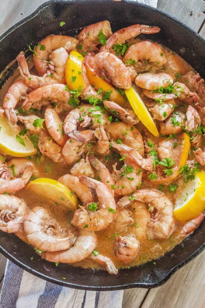 shrimp in a cast iron skillet cooked in a buttery savory broth.