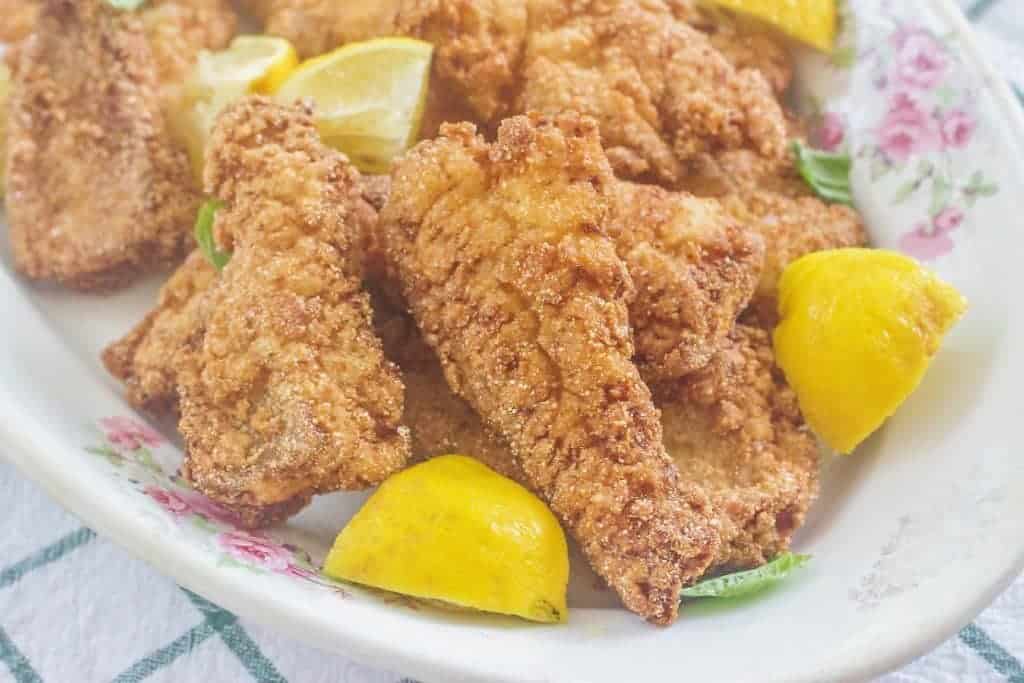 Southern Fried Catfish with lemons on platter.