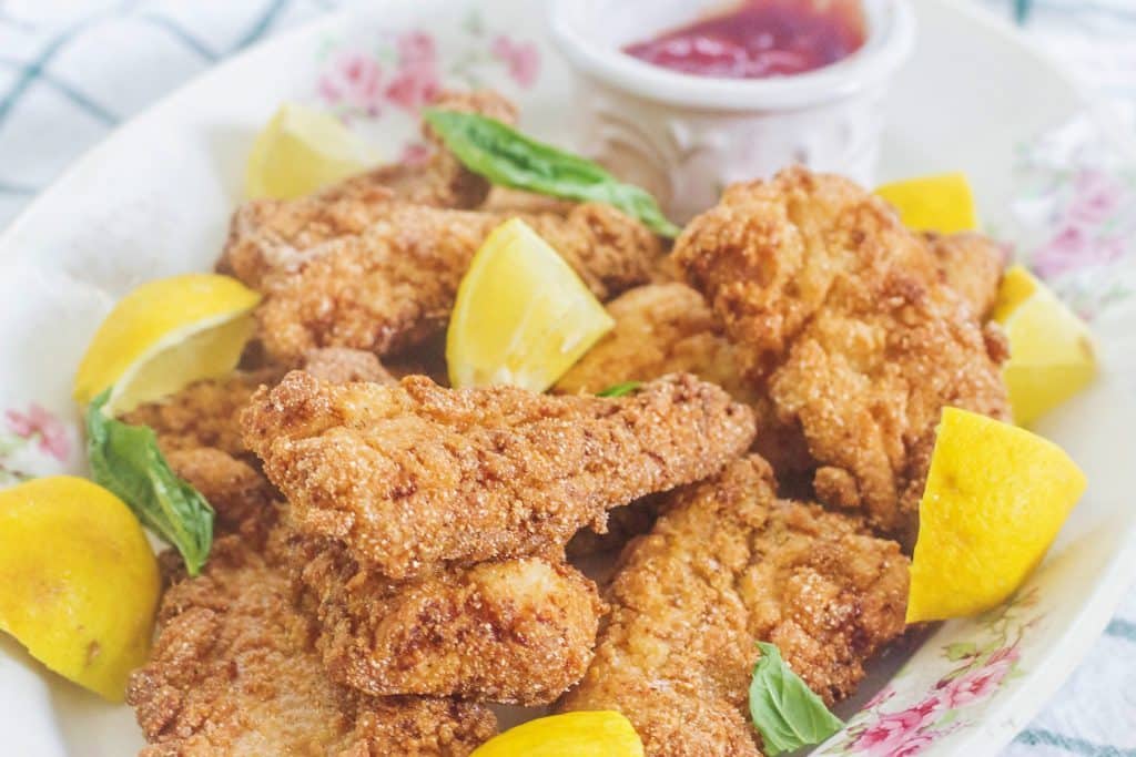 Southern Fried Catfish with lemons and dipping sauce on plate.