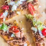 Grilled Flatbread Taco Pizza with Creamy Taco Sauce. Made with pre-packaged naan bread, taco seasoned ground beef and your favorite taco toppings. Topped with an easy and creamy homemade taco sauce.