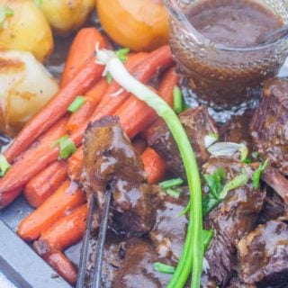 pot roast with vegetables and gravy on a platter
