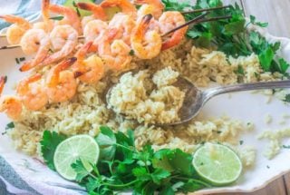 skewered shrimp with cilantro lime rice on a platter