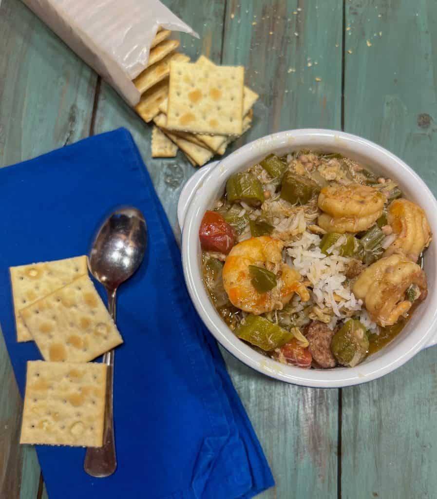 shrimp and crab gumbo in a bowl with crackers on the side
