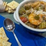 a bowl of shrimp and crab gumbo with rice and crackers