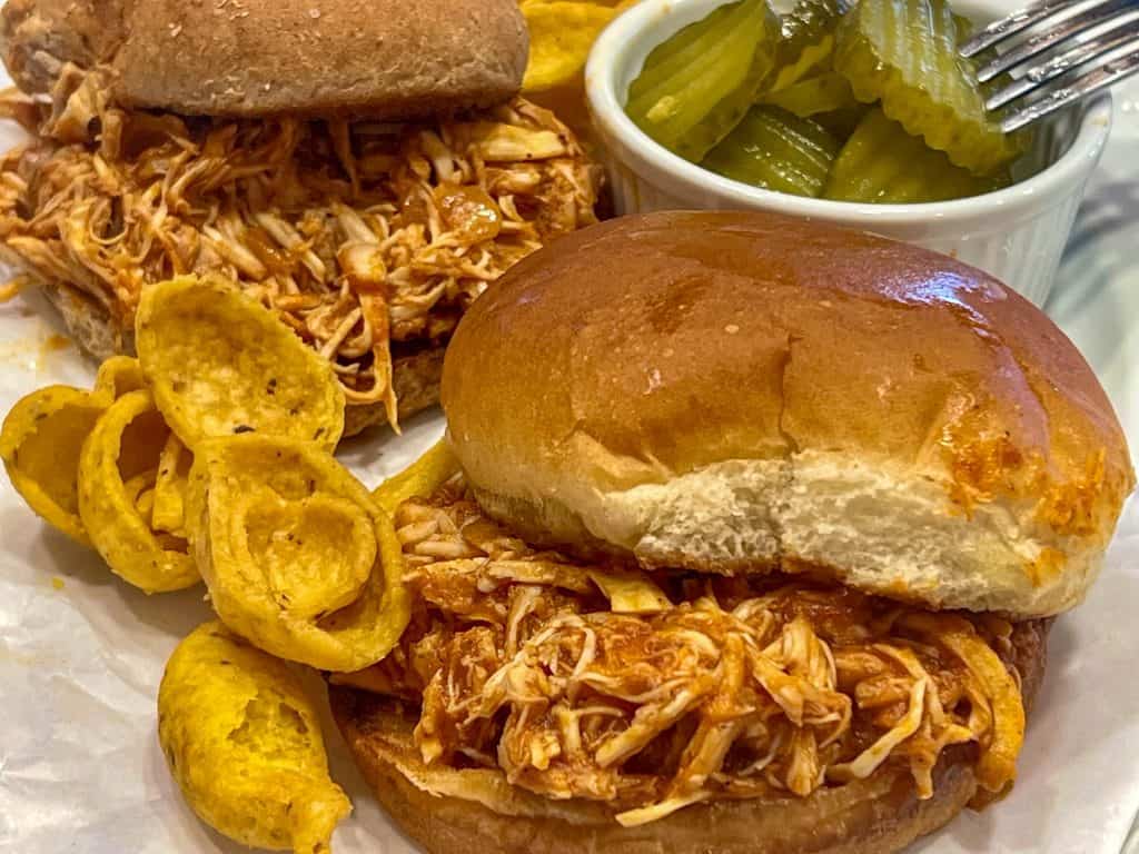 bbq chicken sandwich with chips and pickles