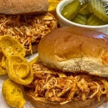 bbq chicken sandwich with chips and pickles