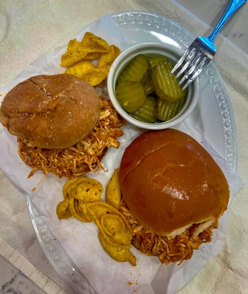 BBQ chicken sandwiches with chips and pickles